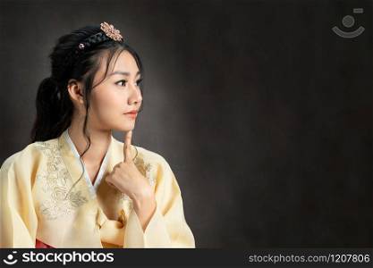 Korean woman wearing traditional korean dress (Hanbok) on black background in studio. Beautiful Korea culture.