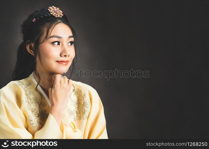 Korean woman wearing traditional korean dress (Hanbok) on black background in studio. Beautiful Korea culture.