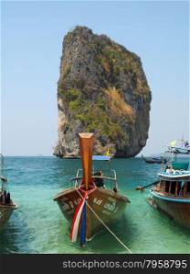 KRABI, THAILAND - FEBRUARY 15, 2015: Traditional Thai wooden longtail boat waits on the shore of Bamboo Island for passengers on a day trip from Phi Phi Island.