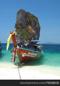 KRABI, THAILAND - FEBRUARY 15, 2015: Traditional Thai wooden longtail boat waits on the shore of Bamboo Island for passengers on a day trip from Phi Phi Island.