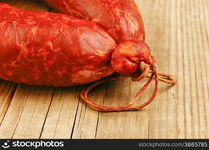 Krakow sausage isolated on the wooden table