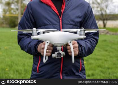 Krasnodar, Russia - May 15, 2017: A man with a quadrocopter in his hands. A white drone is being prepared for the flight. Phantom. A man with a quadrocopter in his hands. A white drone is being p