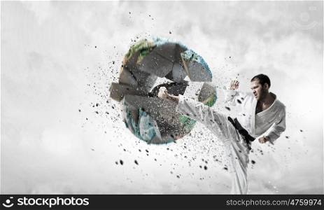 Krate man in action. Determined karate man breaking Earth planet. Elements of this image are furnished by NASA