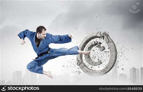 Krate man in action. Determined karate man breaking stone copyrighting sign