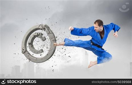 Krate man in action. Determined karate man breaking stone copyrighting sign