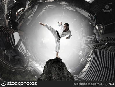 Krate man in action. Karate man in jump against cloudy background