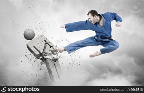 Krate man in action. Karate man in jump attacking stone opponent