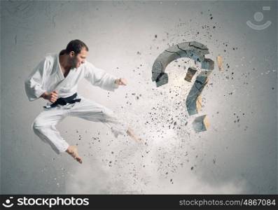 Krate man in action. Karate man in jump breaking question mark