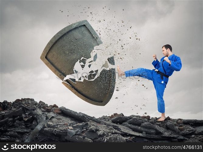 Krate man in action. Karate man in jump breaking stone shield