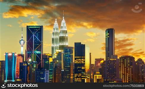 Kuala Lumpur City skyline with urban skyscrapers at sunset.