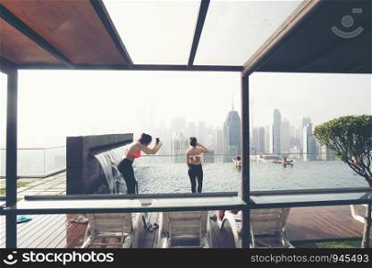 KUALA LUMPUR, MALAYSIA : FEBRUARY 21, 2019 : Vacation in Kuala-Lumpur. Young woman enjoy swimming in roof top pool with beautiful city view