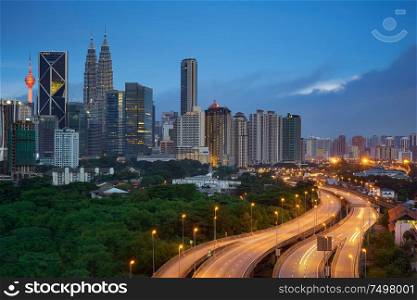 Kuala Lumpur night cityscape skyline with illuminated highway flyover road