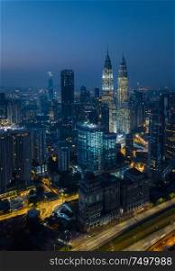 Kuala Lumpur night cityscape skyline with illuminated highway flyover road , Aerial view angle from drone