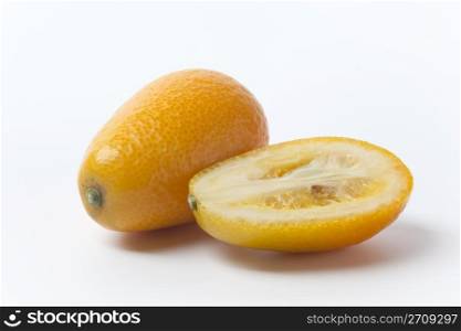 Kumquats whole and half on white background