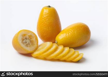 Kumquats whole and slices on white background