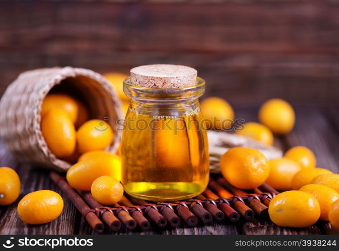 kumqwat oil in bank and on the wooden table