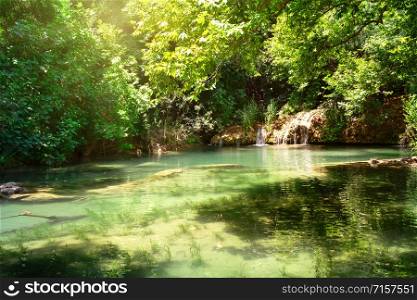Kursunlu Nature Park and waterfall with the lake. Bright greenery, turquoise lake water. Summer landscape. Antalya, Turkey. Kursunlu Nature Park and waterfall with the lake