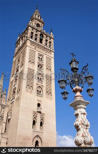 La Giralda, bell tower of the Seville Cathedral and an old fountain lamp, Spain, Andalusia region.
