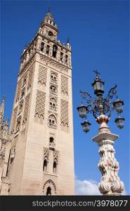 La Giralda, bell tower of the Seville Cathedral and an old fountain lamp, Spain, Andalusia region.