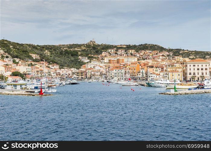 La Maddalena village seen from the water in La Maddalena island, Sardinia, Italy, you arrive this island with the ferry from Palua on the italien island of sardinia. La Maddalena village in La Maddalena island, Sardinia, Italy. La Maddalena village in La Maddalena island, Sardinia, Italy