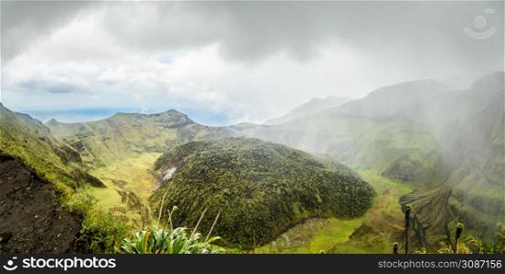 La Soufriere volcano crater panorama with tuff cone hidden in green and pouring rain, Saint Vincent and the Grenadines