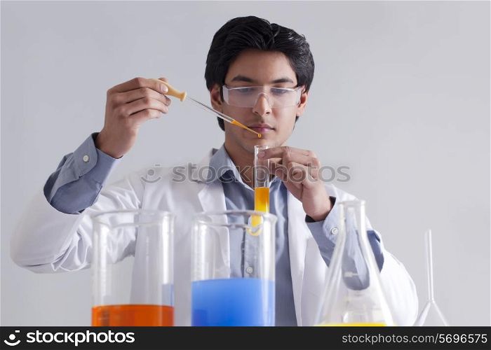 Lab technician adding solution to test tube