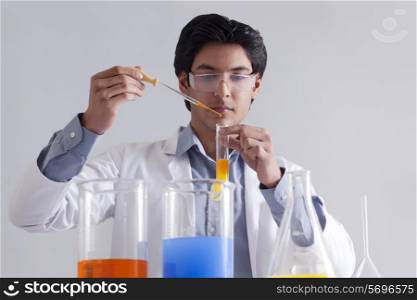 Lab technician adding solution to test tube