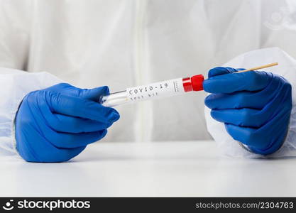 Lab technician holding swab collection kit,Coronavirus COVID-19 specimen collecting equipment,DNA nasal and oral swabbing for PCR polymerase chain reaction laboratory testing procedure,closeup of hand