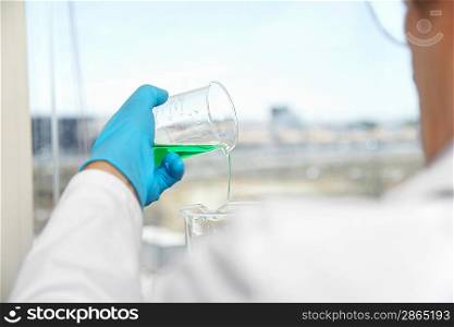 Lab Technician Pouring Blue-green Liquid
