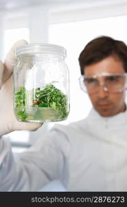 Lab Worker Examining Jar of Herbs