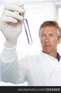 Lab Worker Examining Test Tube of Violet Liquid