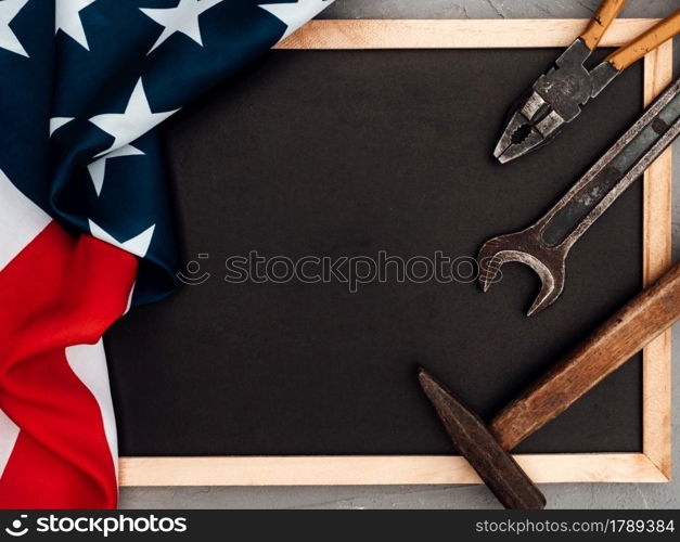 LABOR DAY. Hand tools and the Flag of the United States of America lying on the table. View from above, close-up. Congratulations to family, relatives, friends and colleagues. National holiday concept. LABOR DAY. Hand tools lying on the table