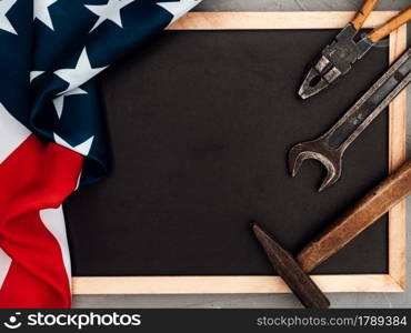 LABOR DAY. Hand tools and the Flag of the United States of America lying on the table. View from above, close-up. Congratulations to family, relatives, friends and colleagues. National holiday concept. LABOR DAY. Hand tools lying on the table