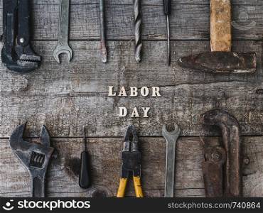 LABOR DAY. Hand tools and wooden letters lying on the table. Top view, close-up. Preparing for the celebration. Congratulations to loved ones, family, relatives, friends and colleagues. LABOR DAY. Hand tools and wooden letters