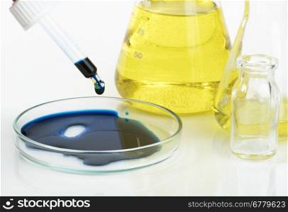Laboratory glassware equipment. Dropper with blue liquid