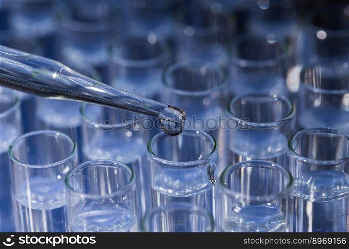 Laboratory glassware with pipette dropping fluid into test tube