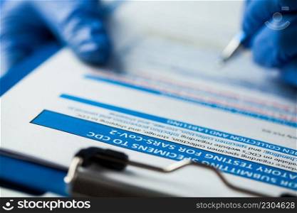 Laboratory technician checking CDC specimen submitting form, laboratory testing for SARS-CoV-2 COVID-19 Coronavirus disease infection,global pandemic crisis,swab collection patient specimen procedure