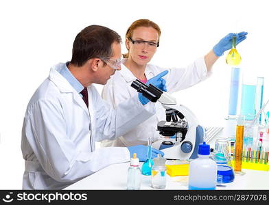 laboratory with two scientist working with test tubes flask and microscope