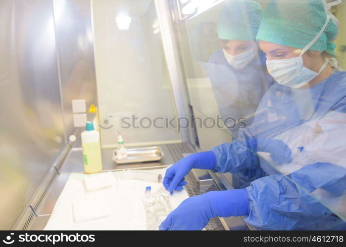 Laboratory workers reaching through screen