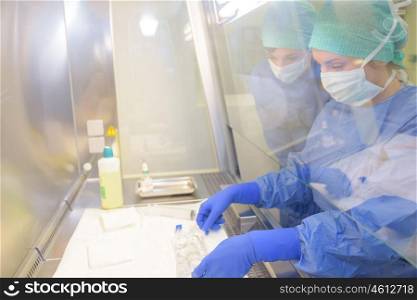 Laboratory workers reaching through screen