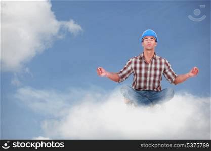 Laborer doing yoga sitting on a cloud