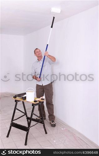Laborer painting ceiling