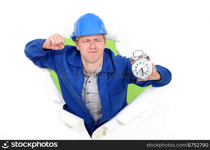 Laborer waking up with an alarm clock in the hand