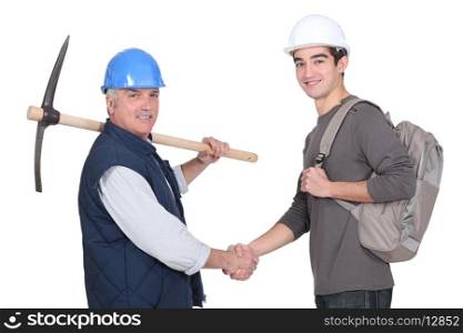 Laborer welcoming young apprentice
