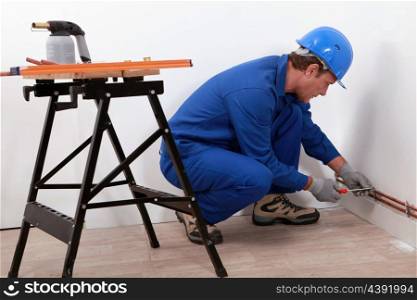 Laborer with screwdriver and blowtorch
