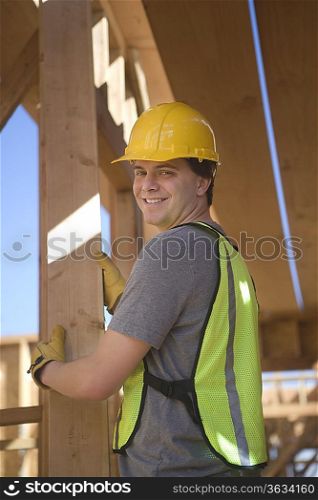 Labourer positioning plank of wood