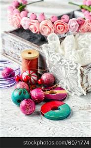 Lace,beads and ornaments in the wooden box on bright background