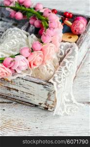 Lace,beads and ornaments in the wooden box on bright background