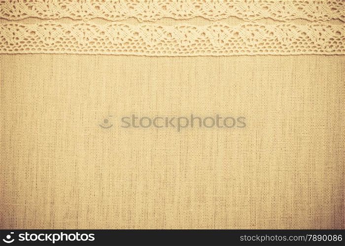 Lace ribbon on natural linen, bright cloth fabric background. Border frame. vintage style
