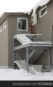 Ladder in snow on the second floor with windows